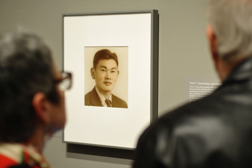 TO GO WITH AFP STORY by Shaun TANDON, US-Japan-museum-history-racism Guests look a photograph of Fred Korematsu during a presentation of his portrait to the National Portrait Gallery on February 2, 2012 in Washington, DC. Fred Korematsu was a US citizen of Japanese ancestry who was imprisoned for defying a relocation order. Seventy years after the United States detained citizens of Japanese ancestry, the gallery that honors noteworthy Americans on Thursday dedicated a portrait of the man who defied the order. AFP PHOTO/Mandel NGAN (Photo credit should read MANDEL NGAN/AFP via Getty Images)