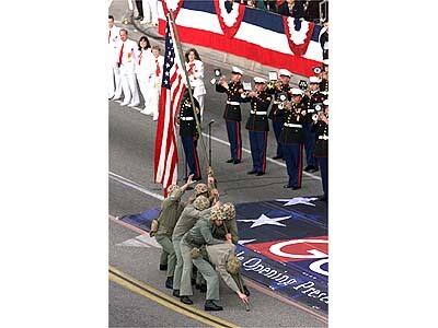 Members of the U.S. Marine Corps Marching Band perform as fellow Marines reenact the raising of the U.S. Flag at Iwo Jima during World War II.