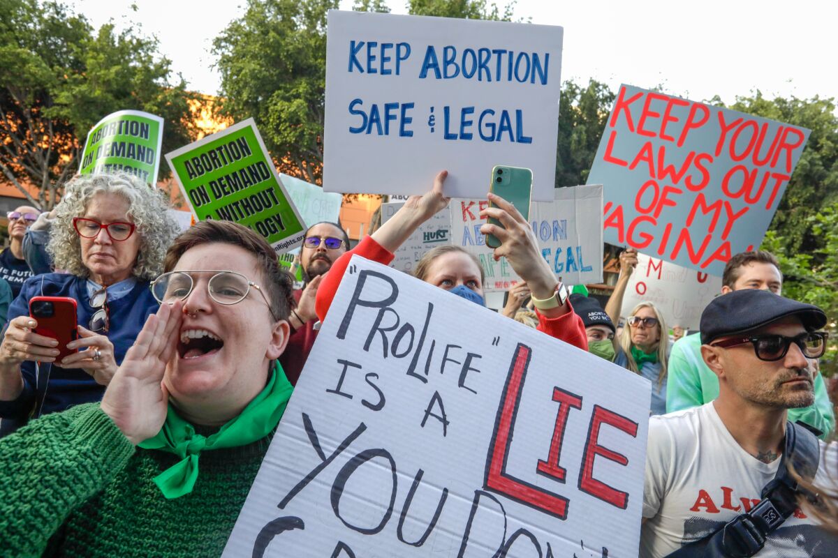 A crowd of abortion rights supporters rally with signs, including one reading "'ProLife' is a lie."