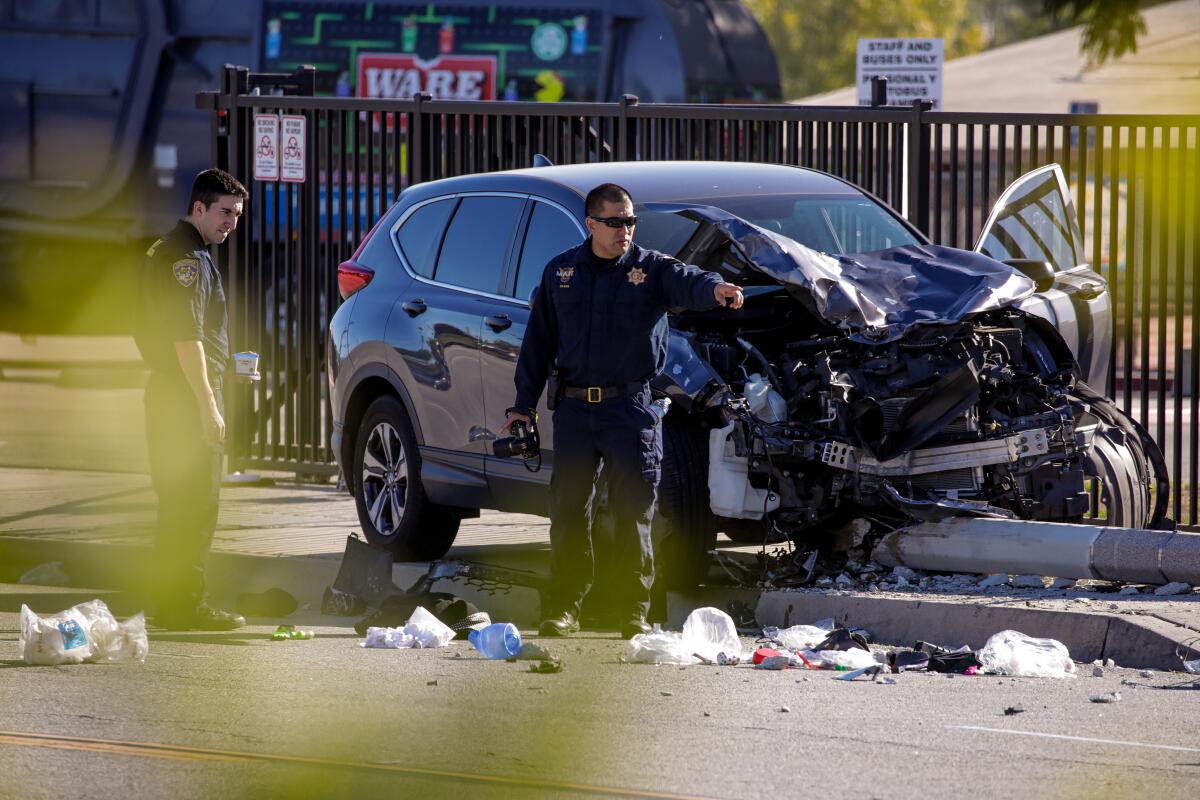 Two police officers survey the scene of a car accident