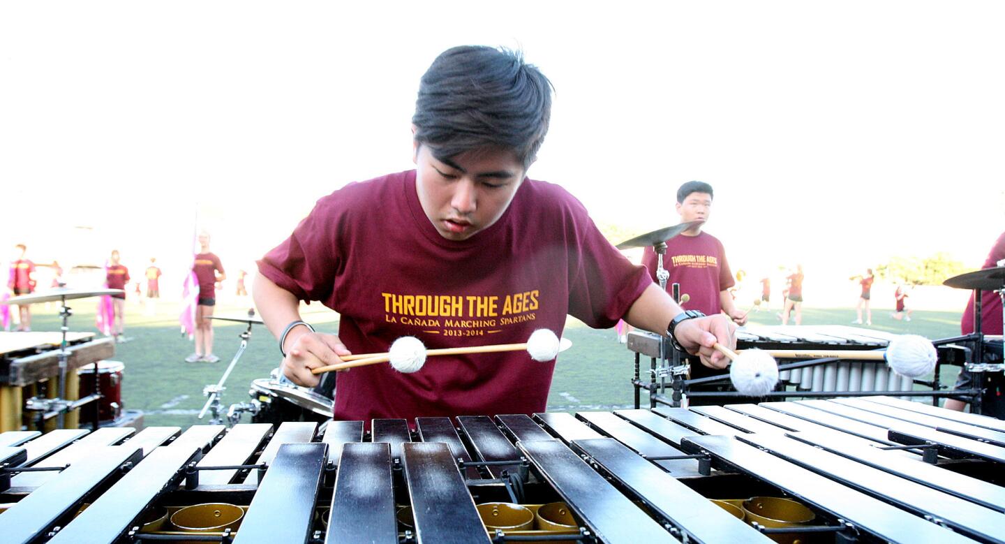 Noah Kim, 17, with the La Canada High School percussion section, plays the marimba with the La Canada High School Marching Band during a practice performance for the upcoming home football game for parents and friends of the school on Thursday, August 15, 2013.