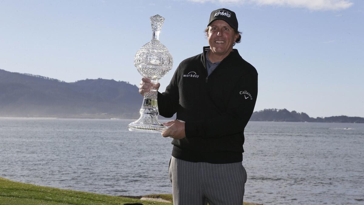Phil Mickelson poses with his trophy after winning the Pebble Beach Pro-Am on Monday.