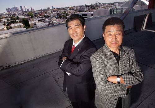 Chris Nam, left, and Gab Jea Cho on top of the Korean American Federation of Los Angeles building in Koreatown. Cho, a Federation board member who is in charge of the community security project, fears that the crime issue could make Koreatown a less attractive place for South Koreans to invest in and visit. Nam is the President of the Korean American Federation of Los Angeles.