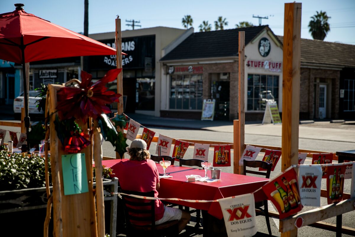 A customer takes in a meal at an on-street patio in Ocean Beach in December 2020.