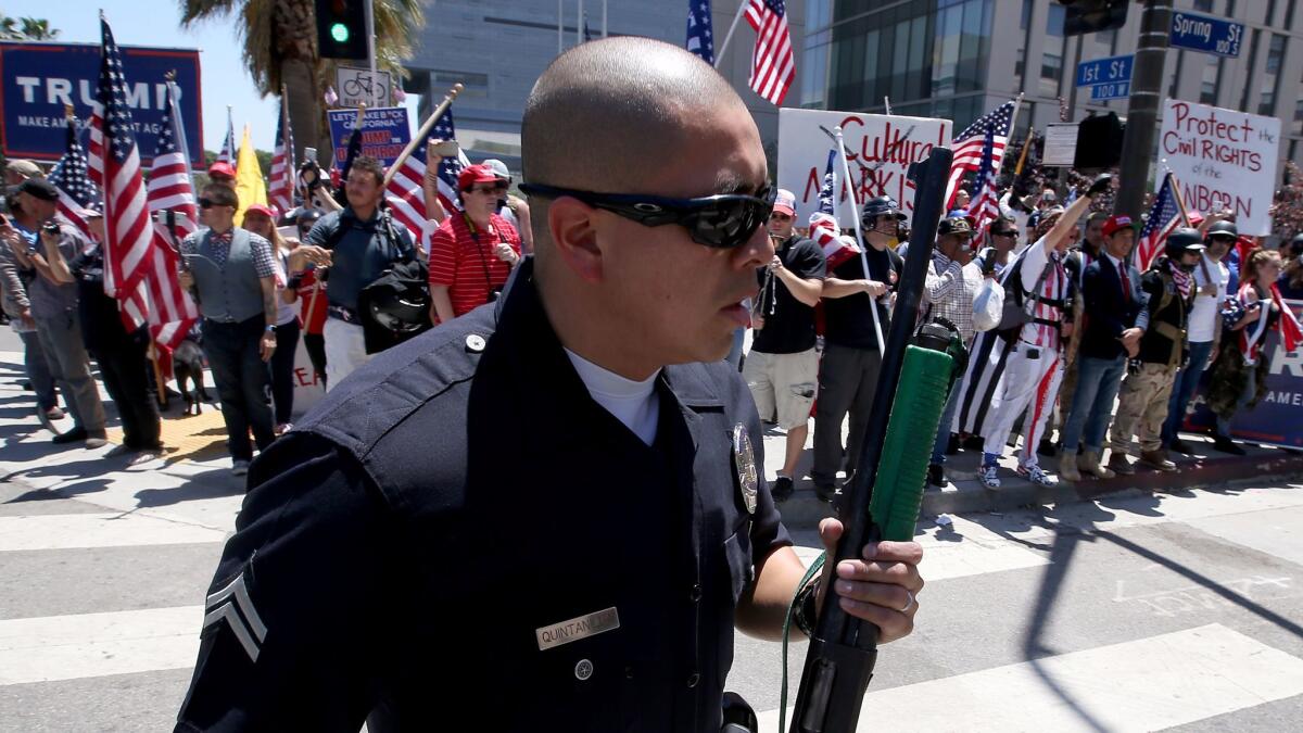 LAPD officers form a wall between pro- and anti-Trump protesters as they converge at 1st and Spring streets in downtown Los Angeles at the conclusion of separate May Day marches and rallies. (Luis Sinco / Los Angeles Times)
