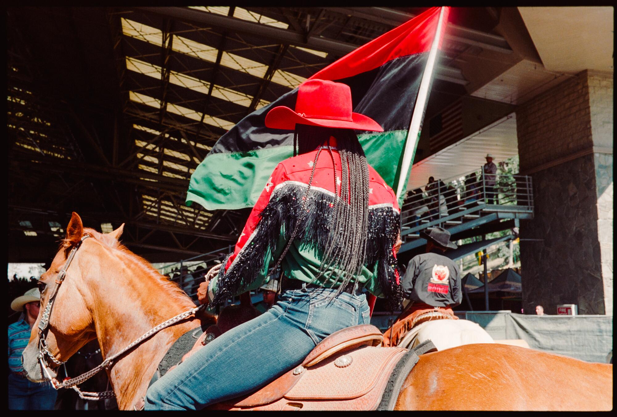 Black cow girl carrying the Pan African flag