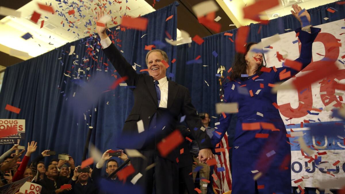 Democratic Senate candidate Doug Jones and his wife Louise wave to supporters in Birmingham, Ala. on Dec. 12, 2017.