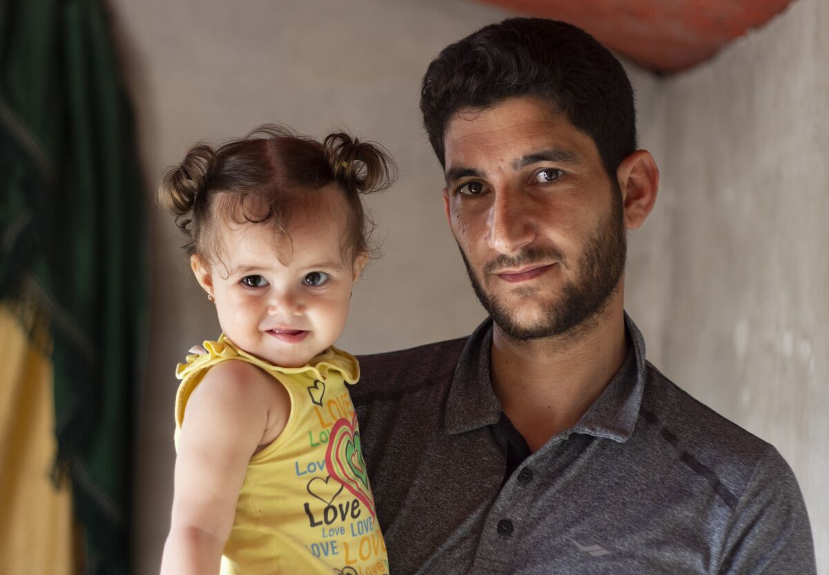 Abdel Hamid Yousef with his 11-month-old daughter, Aya, at a settlement for the displaced near the town of Atmeh in northern Syria.