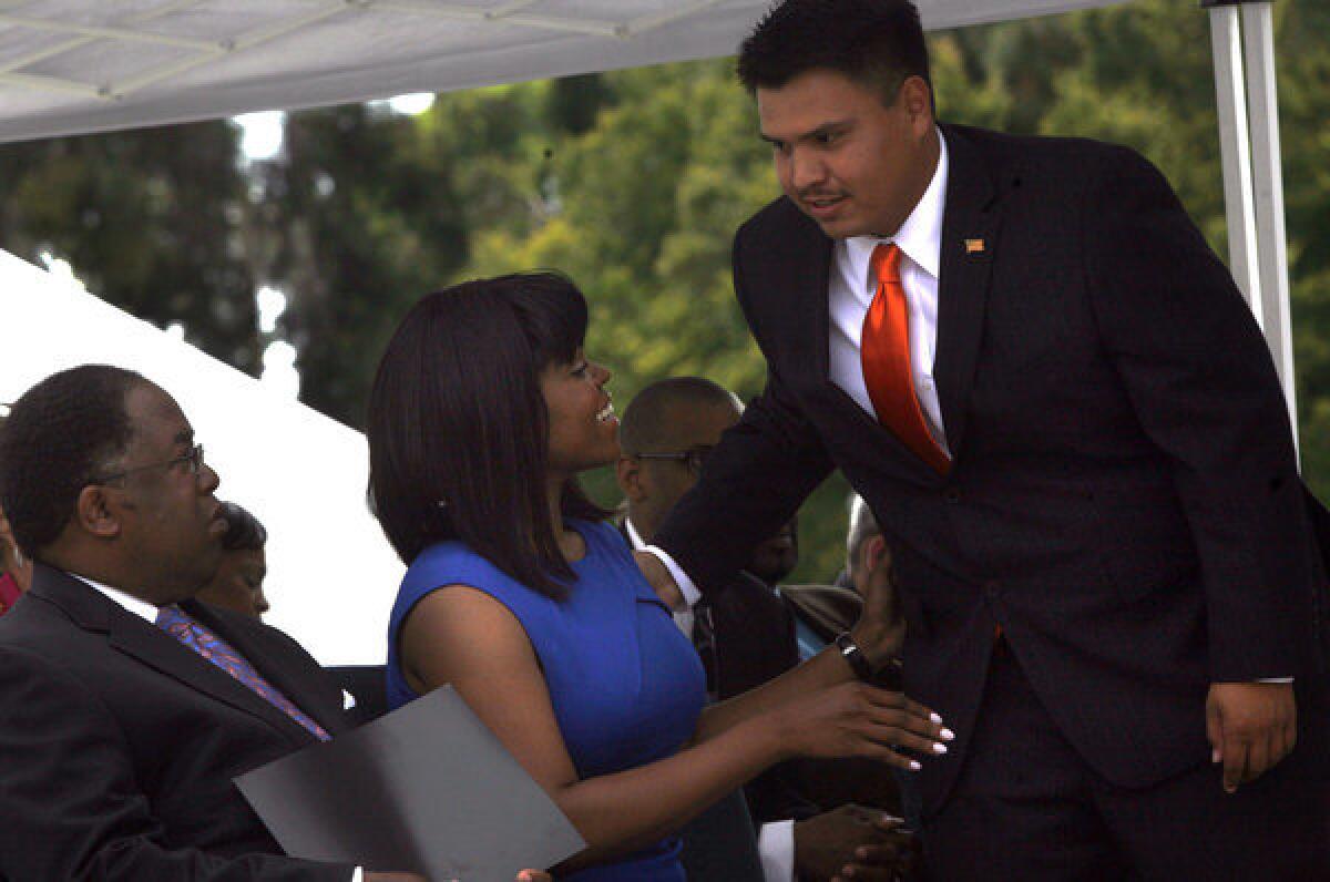 New Compton City Councilman Isaac Galvan, right, greets new Compton Mayor Aja Brown. The city has fired his aide, Angel Gonzalez, who had previous convictions for political misconduct.