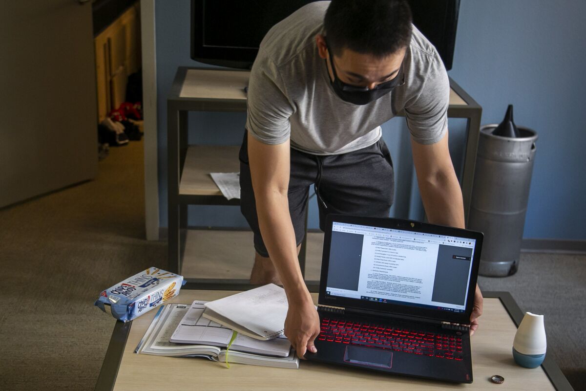 USC senior Ethan Recinto, 21, gets set up for his Japanese class in his University Gateway apartment.