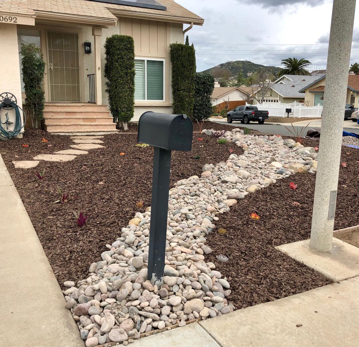 The Perrells tamed their front yard in one long weekend, removing the grass and starting with a winding riverbed of rocks.