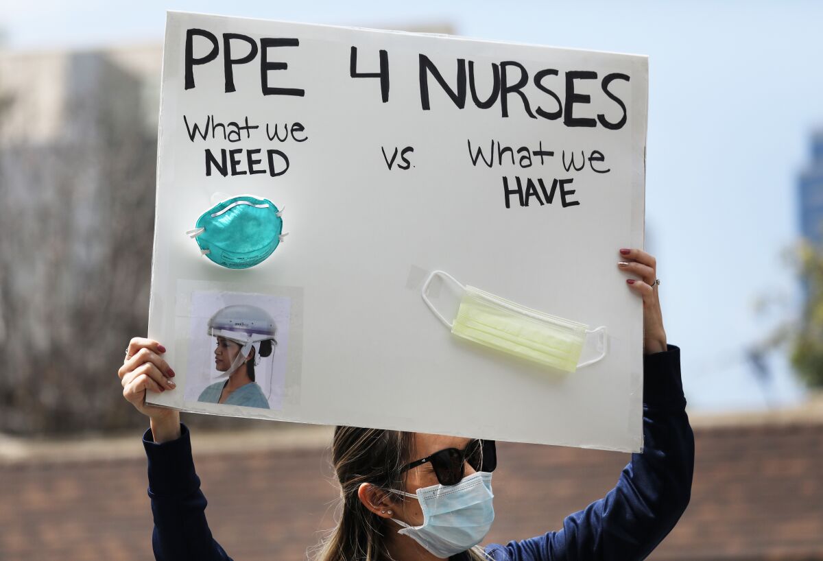 A nurse holds up a sign to protest the lack of personal protective gear available at UCI Medical Center in Orange.