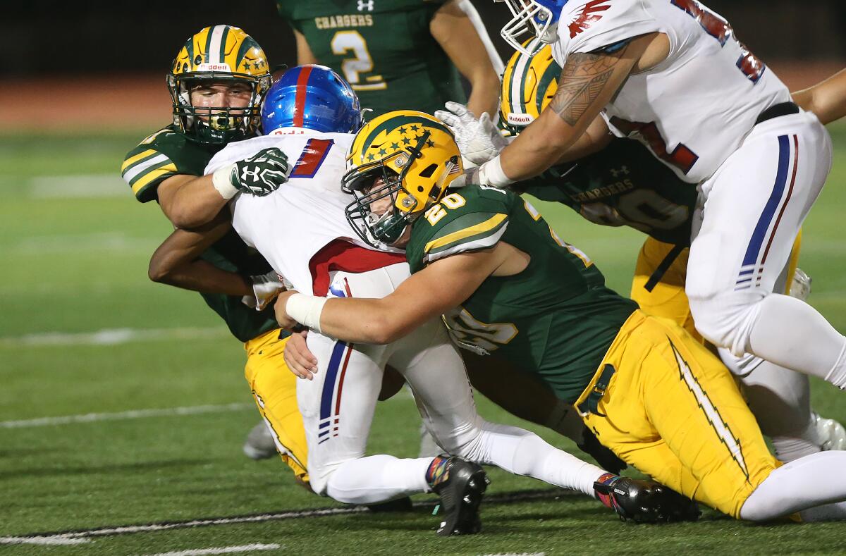 Edison’s Trent Fletcher (20) helps bring down Los Alamitos’ Oscar Brown V for a loss in a Sunset League opener at Cap Sheue Field on Oct. 4, 2019.