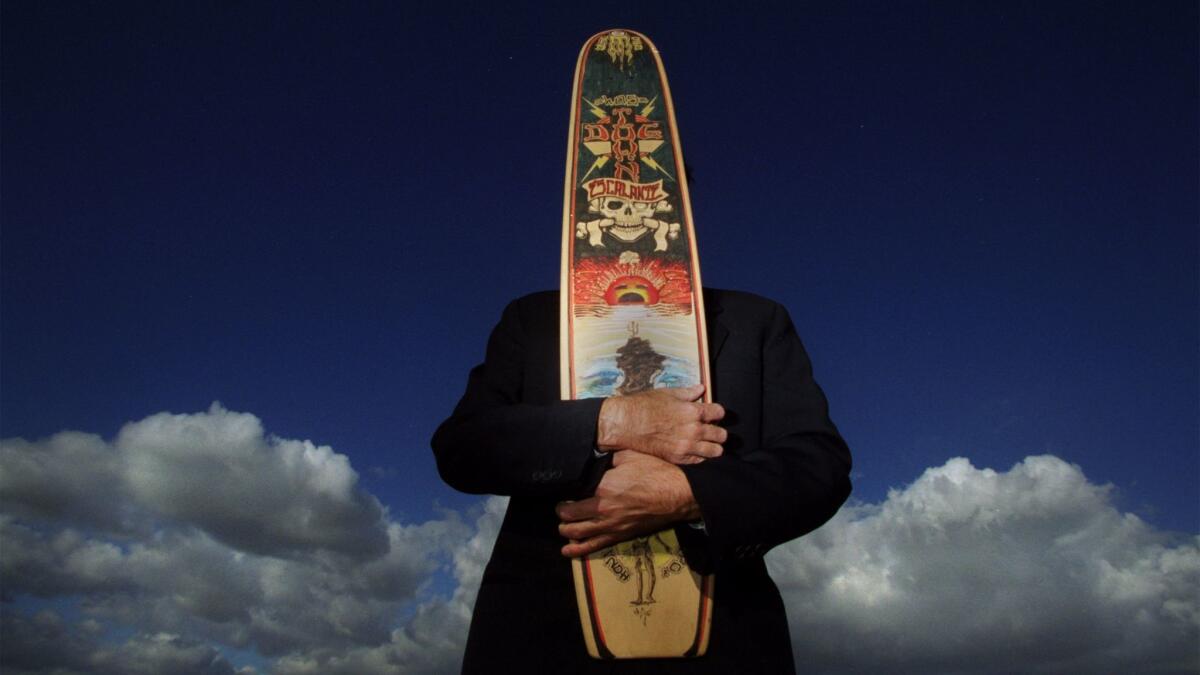 Greg Escalante holds a painted skateboard by artist Kevin Ancell in 2001. (Francine Orr / Los Angeles Times)