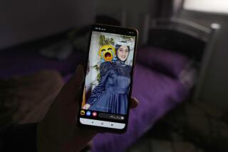 Palestinian Barakat Jabr, 15, displays a photo of his sister Bana Bakr, 13, on his mobile phone in her bedroom at the family house, as he waits for her funeral, in the West Bank village of Qaryut, south of Nablus, Saturday, Sept. 7, 2024. Bakr was killed by Israeli fire the Palestinian health ministry said. The Israeli army said they were reviewing the incident. (AP Photo/Nasser Nasser)