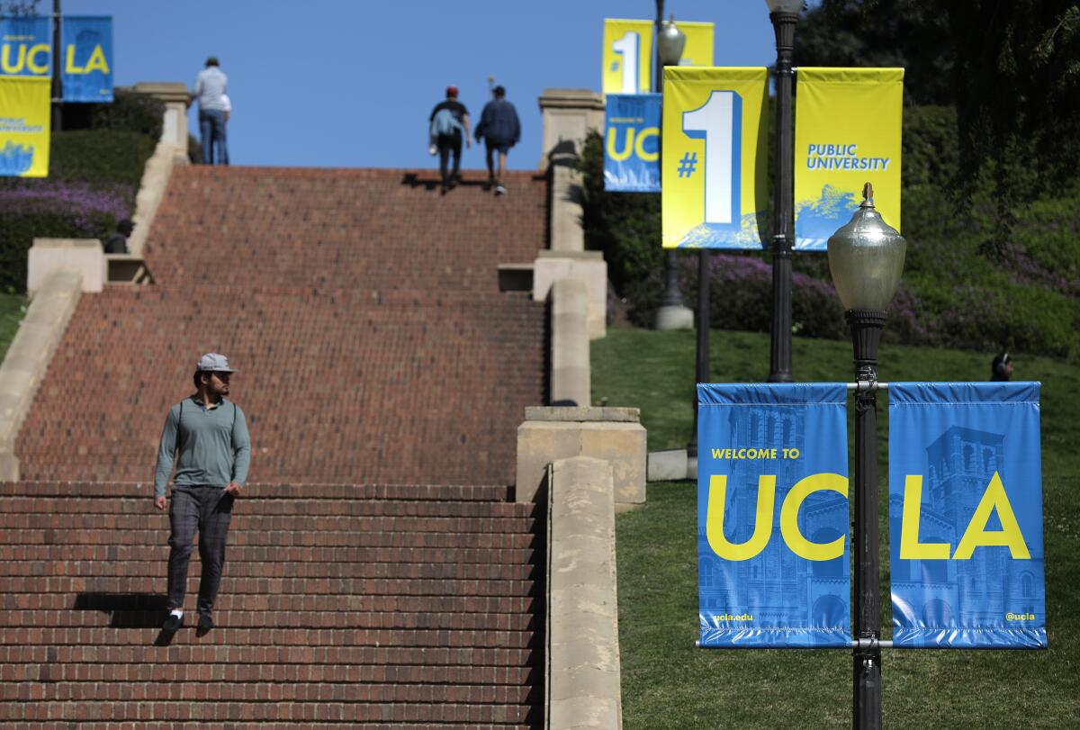 People walk down stairs next to UCLA banners