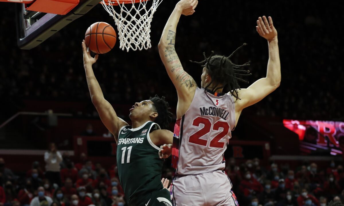 Michigan State guard A.J. Hoggard (11) drives to the basket against Rutgers guard Caleb McConnell (22) during the first half of an NCAA college basketball game in Piscataway, N.J., Saturday, Feb. 5, 2022. (AP Photo/Noah K. Murray)