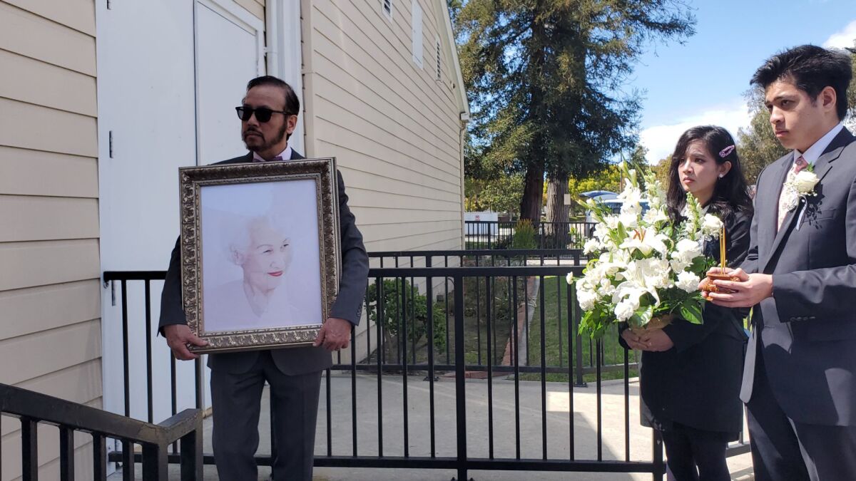 Viet Le holds a portrait of his beloved mother, Thai Thanh, following a private funeral procession for the singer in Westminster.