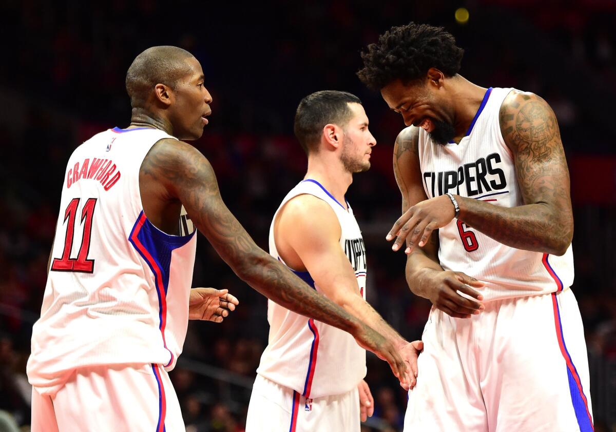 Clippers center DeAndre Jordan (6) reacts after making a free throw as teammates Jamal Crawford (11) and J.J. Redick (4) give him a pat. The Clippers beat the Trail Blazers, 102-87, to win their third straight game.