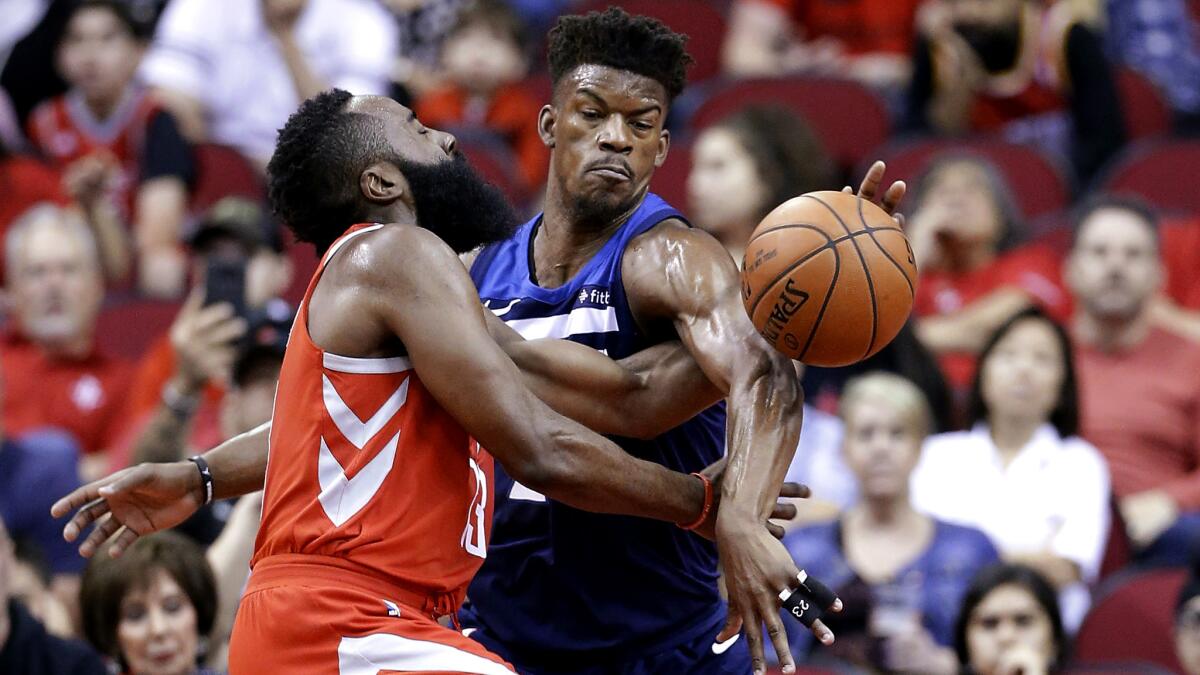 Houston Rockets guard James Harden (13) is fouled on his shot attempt by Minnesota Timberwolves guard Jimmy Butler (23) during the first half of an NBA basketball game Friday, Feb. 23, 2018, in Houston. (AP Photo/Michael Wyke)