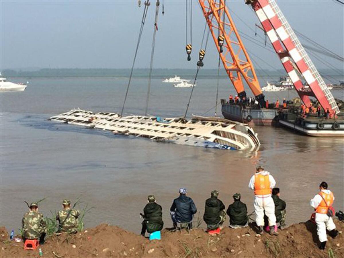 Dos grúas intentan enderezar el casto de un crucero que naufragó en el río Yangtsé en la provincia china de Hubei, el 5 de junio de 2015.