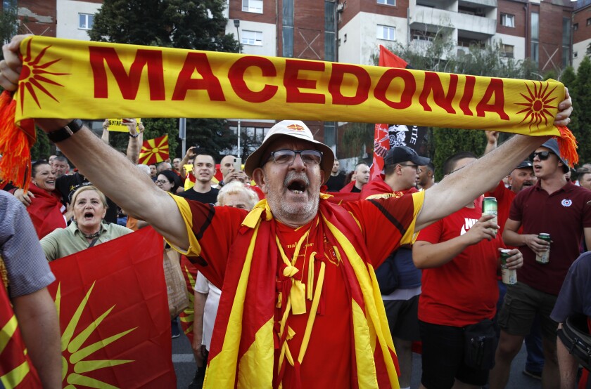 A protester dressed in the national colors attends a protest in front of the government building in Skopje, North Macedonia, on Saturday, July 2, 2022. Tens of thousands of people have gathered late on Saturday in North Macedonia's capital Skopje to protest the latest French presidency proposal on solving bilateral disputes with Bulgaria that gave directions for small Balkan country to open membership talks with the European Union. (AP Photo/Boris Grdanoski)