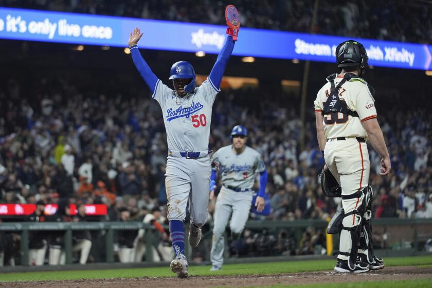 Los Angeles Dodgers' Mookie Betts (50) celebrates as he scores against the San Francisco Giants on Will Smith's double during the 10th inning of a baseball game Monday, May 13, 2024, in San Francisco. (AP Photo/Godofredo A. Vásquez)