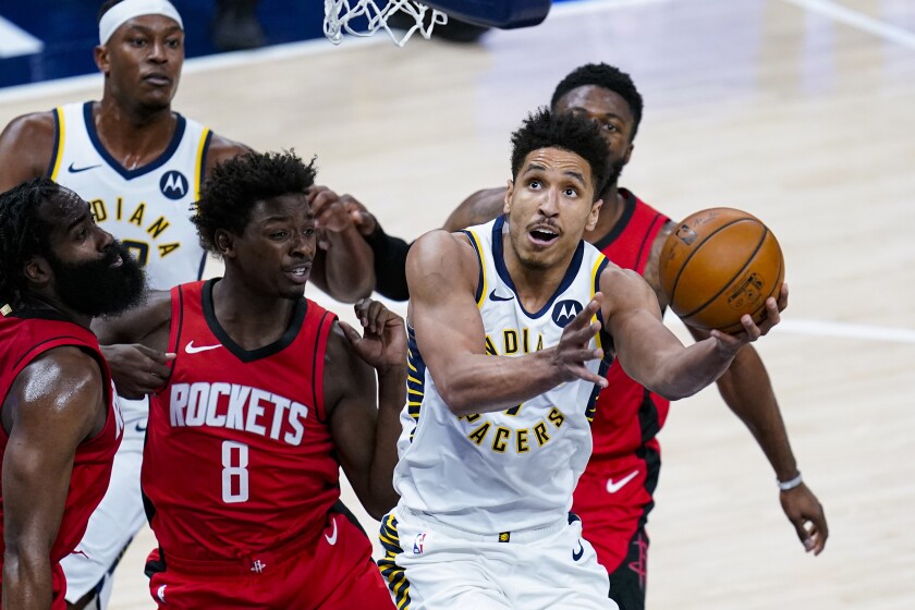 Indiana Pacers guard Malcolm Brogdon (7) shoots in front of Houston Rockets forward Jae'Sean Tate (8) during the first quarter of an NBA basketball game in Indianapolis, Wednesday, Jan. 6, 2021. (AP Photo/Michael Conroy)