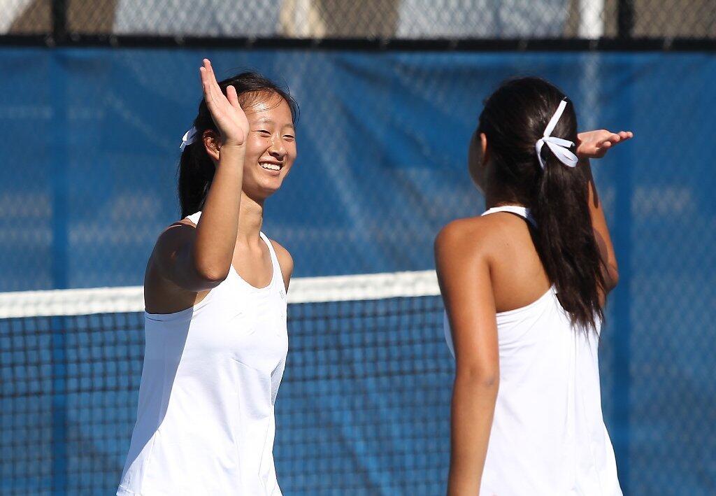 Corona del Mar High's No. 1 doubles team of Erica Chen, left, and Camella Edalat celebrate a point against Newport Harbor in the Battle of the Bay at Newport Harbor on Thursday.