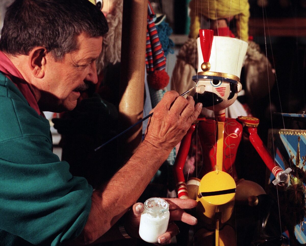 In this 1998 photo, Bob Baker repairs one of his puppets backstage at his Marionette theater.