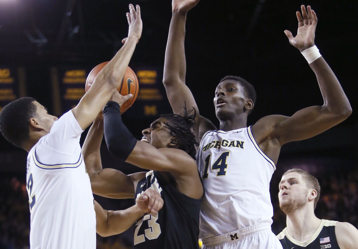 Purdue guard Jaden Ivey (23) goes to the basket against Michigan forward Caleb Houstan, left, and forward Moussa Diabate (14) during the first half of an NCAA college basketball game Thursday, Feb. 10, 2022, in Ann Arbor, Mich. (AP Photo/Duane Burleson)