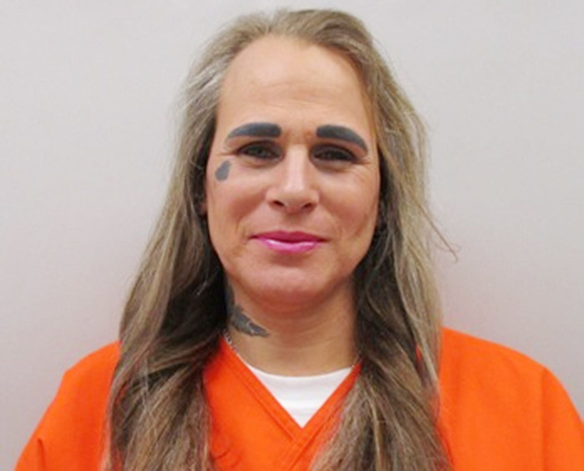 Daralyn Madden, in an orange shirt and wearing long hair, identifies as a transgender woman.