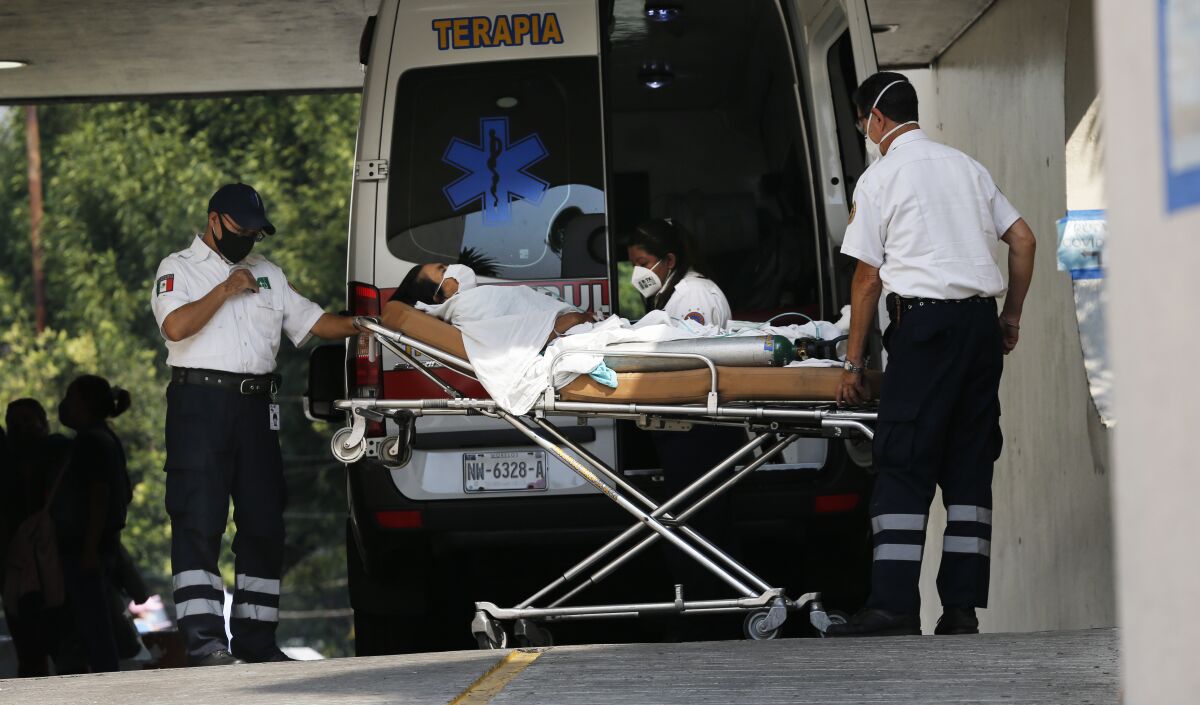 Medical workers carry a patient in respiratory distress from an ambulance May 20 at the Parque de Los Venados hospital in Mexico City. 