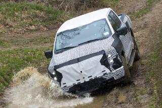 Ford put the Lightning through rigorous off-road tests. Here a truck hits a puddle of water on a dirt road in a forest.