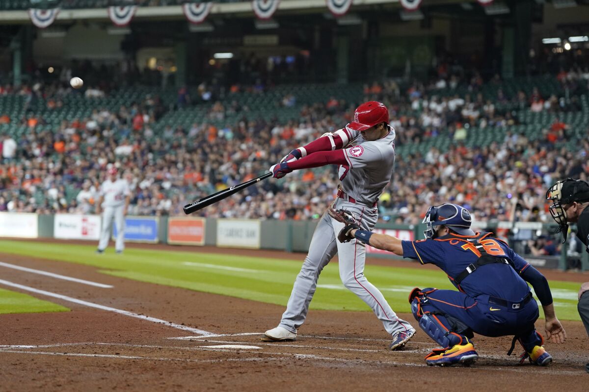 Angels' Shohei Ohtani hits a two-run double as Houston Astros catcher Jason Castro reaches for the pitch.
