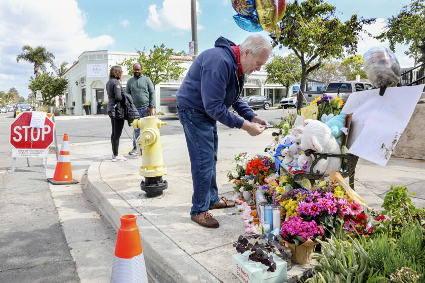 Bernie Stoiber looks over items at a memorial site where 6-year-old boy was killed on the intersection of Kensington Avenue and Biona Drive on Saturday, March 25, 2023.