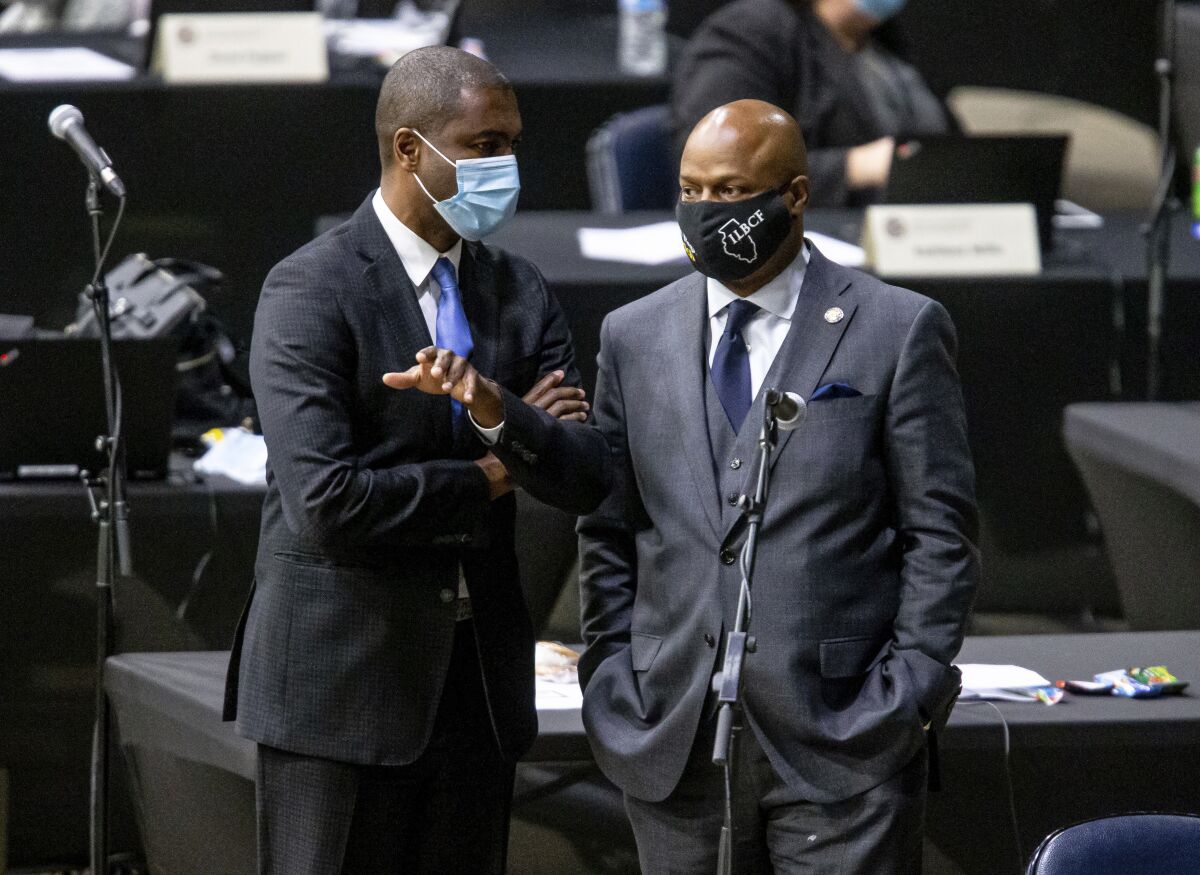 Illinois state Rep. Emanuel "Chris" Welch, right, talks on the House floor with fellow Rep. La Shawn K. Ford on Monday