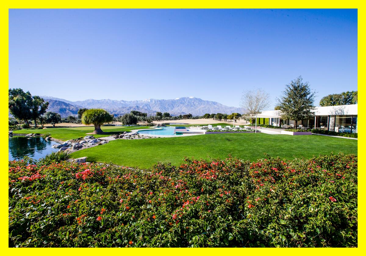A large house with extensive grounds and a pool, with mountains in the distance.