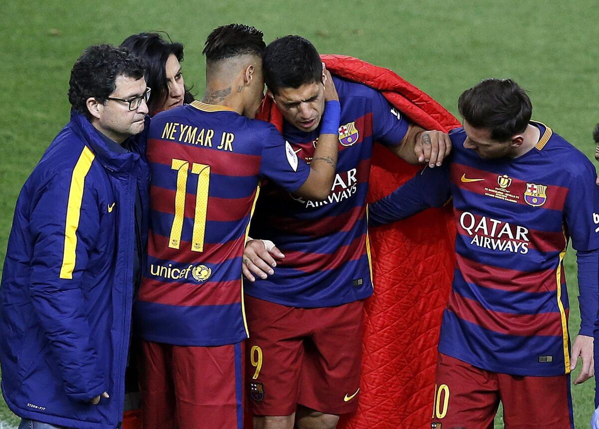 FC Barcelona's Luis Suarez is consoled by teammates Neymar Jr., left, and Lionel Messi after an injury on Sunday.