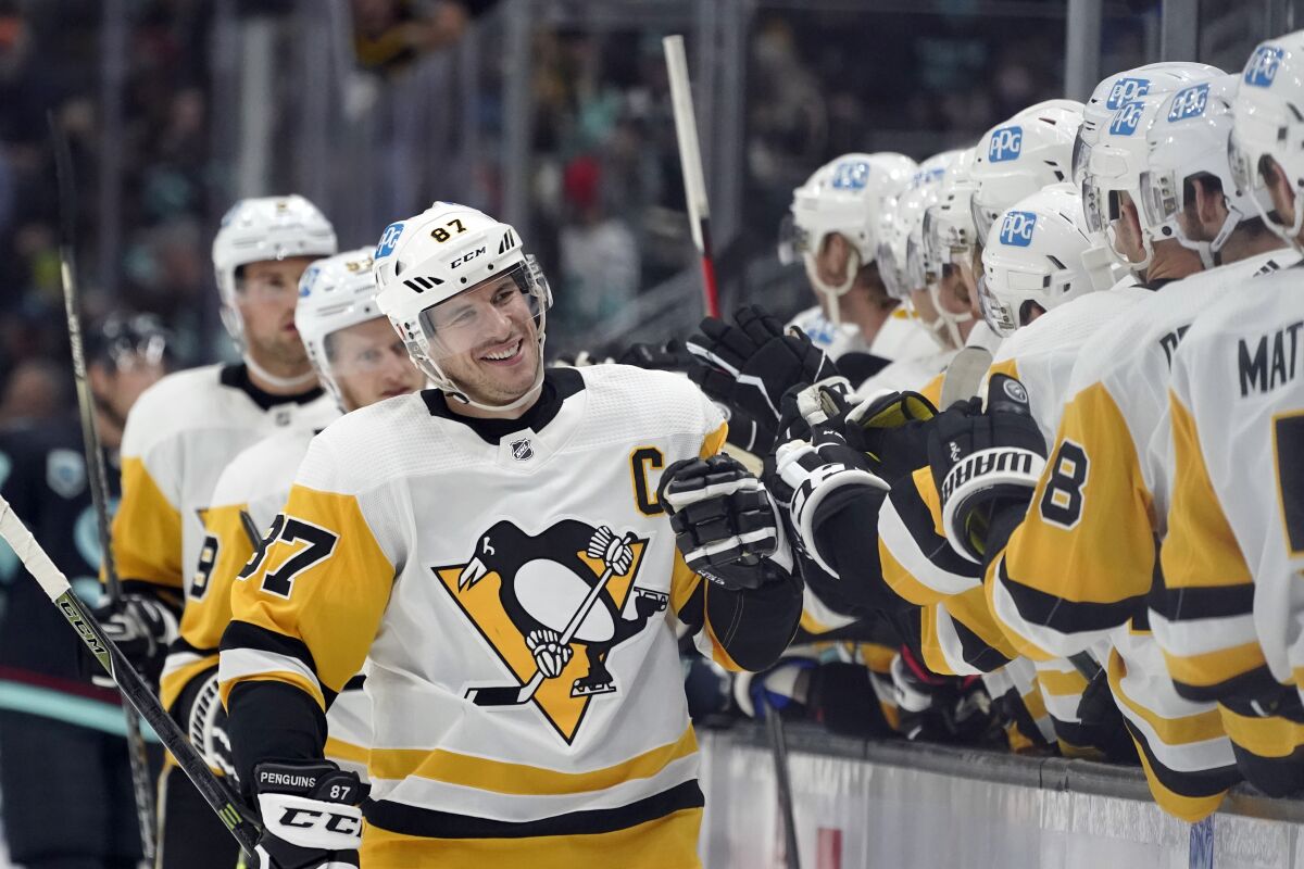 Pittsburgh Penguins center Sidney Crosby, center, greets teammates after he scored a goal against the Seattle Kraken during the first period of an NHL hockey game, Monday, Dec. 6, 2021, in Seattle. (AP Photo/Ted S. Warren)