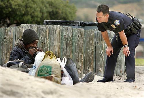 Police Officer Jason Farris talks with a homeless man on Main Beach, part of his job as a community outreach officer. The 3-month-old position is part of a wide-ranging effort by the city to end panhandling, public urination and camping that has drawn complaints from residents and merchants. Photo gallery