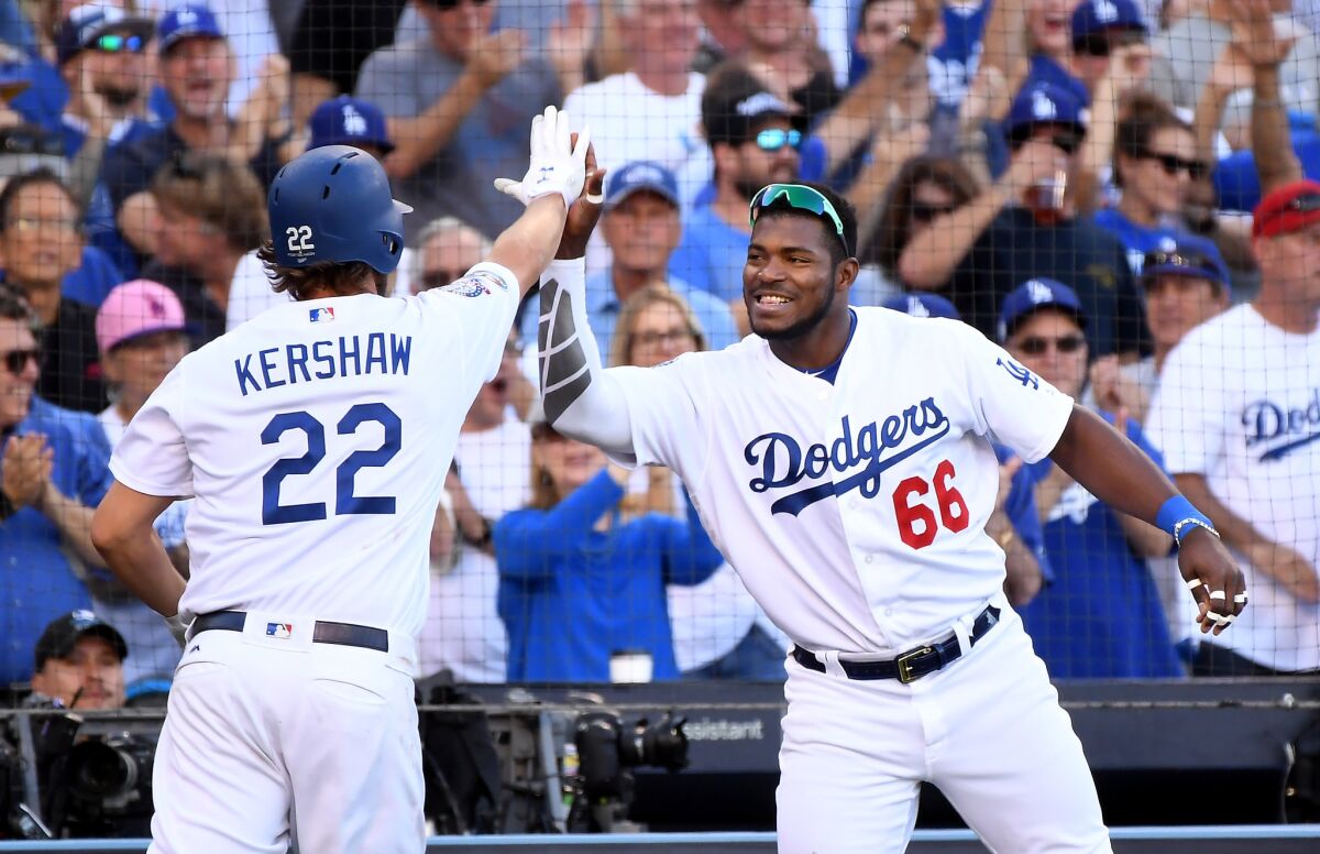 Clayton Kershaw is congratulated by Yasiel Puig after scoring a run.