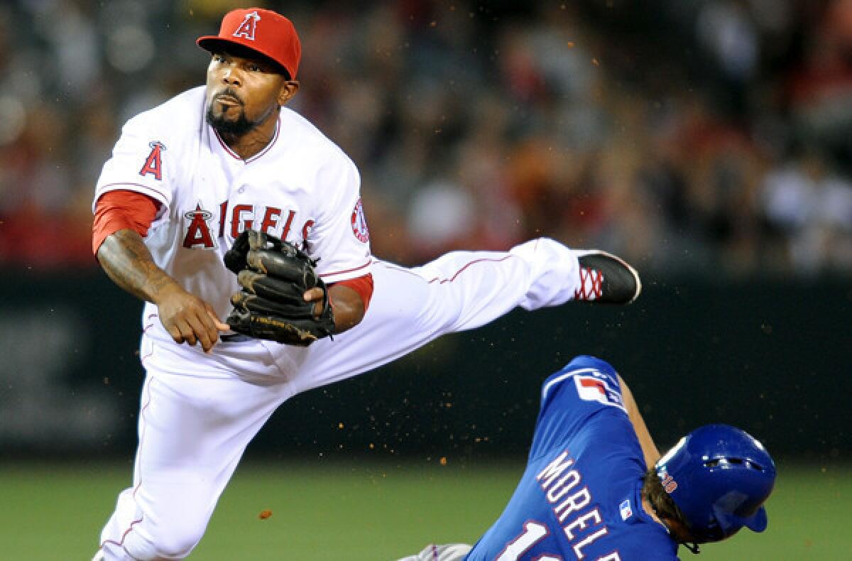 Angels second baseman Howie Kendrick completes a double play while avoiding the slide of Rangers first baseman Mitch Moreland during a game last week.