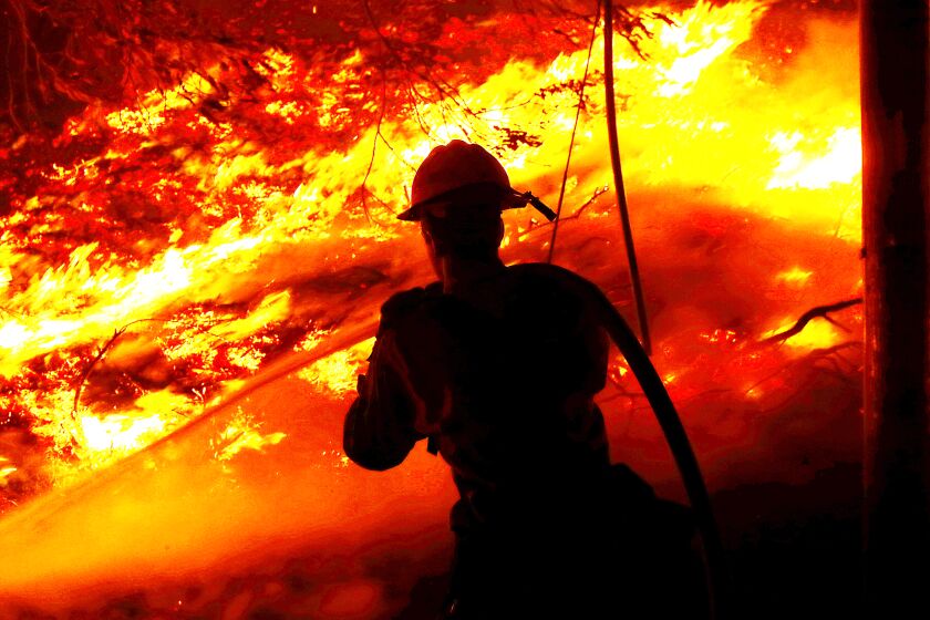  A firefighter battles the Alisal fire along the 101 Freeway near Goleta on Tuesday, Oct. 12, 2021. 