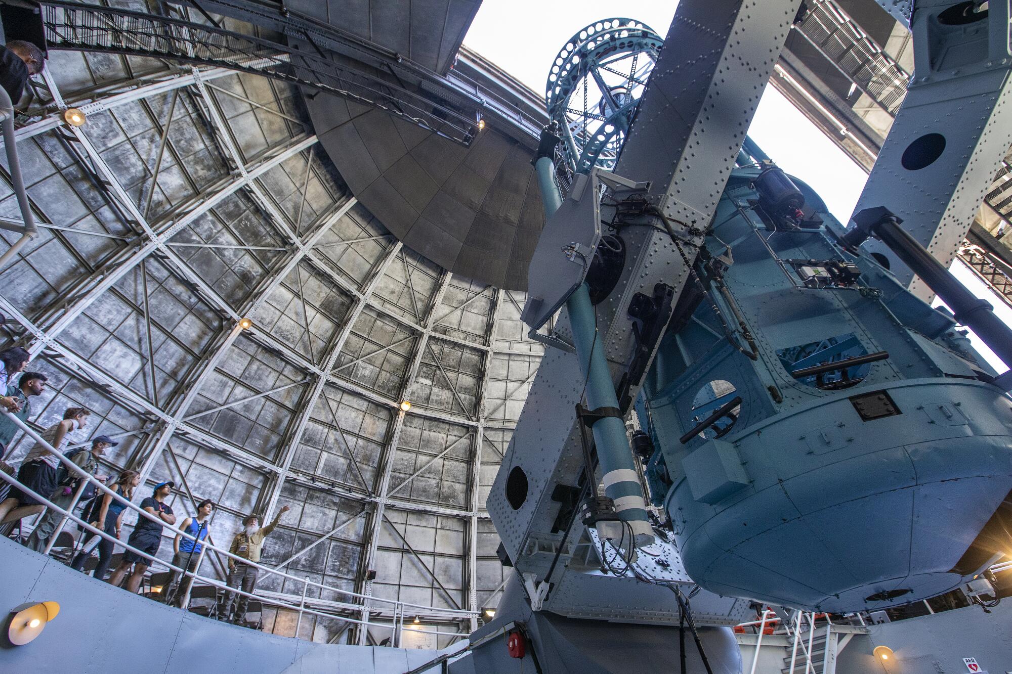 Docent Tim Thompson, right, gives students from USC a tour of the 100-inch telescope at Mt. Wilson Observatory. 