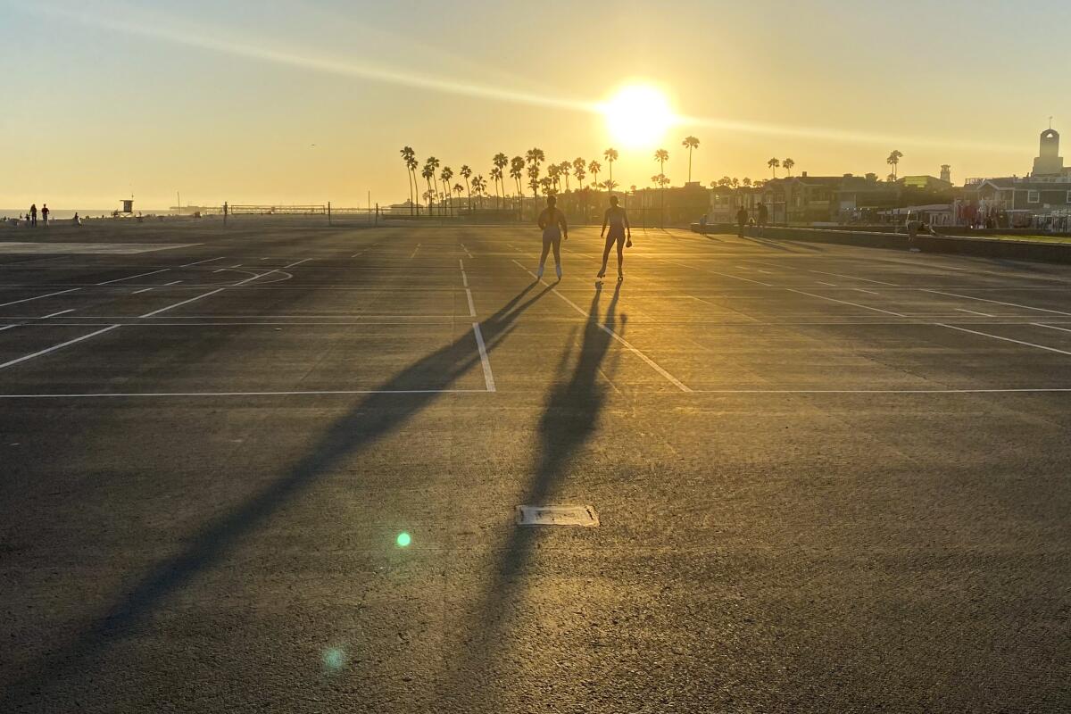 Roller skaters on Newport Beach Blacktop roll toward a glowing sunset and palm trees.