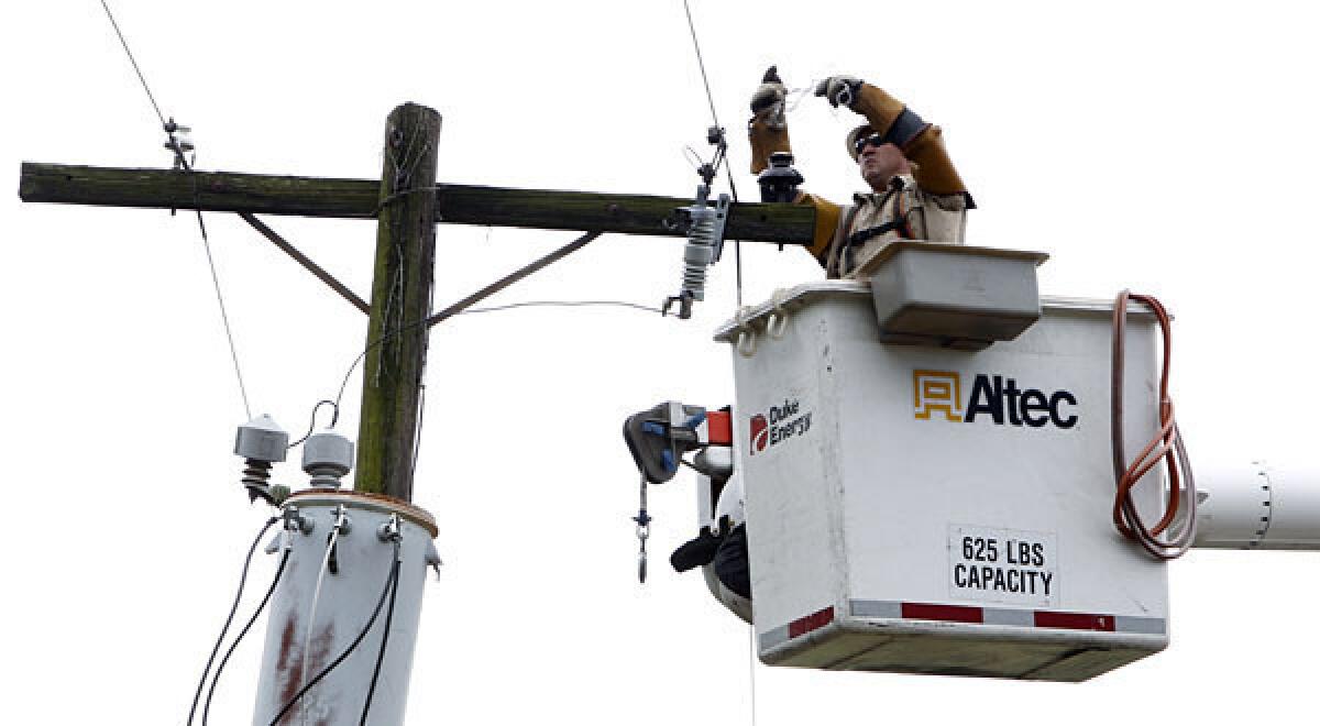 A Duke Energy worker repairs a line after a storm. The company has written off a $10-million line of credit it guaranteed to help produce the Democratic National Convention.