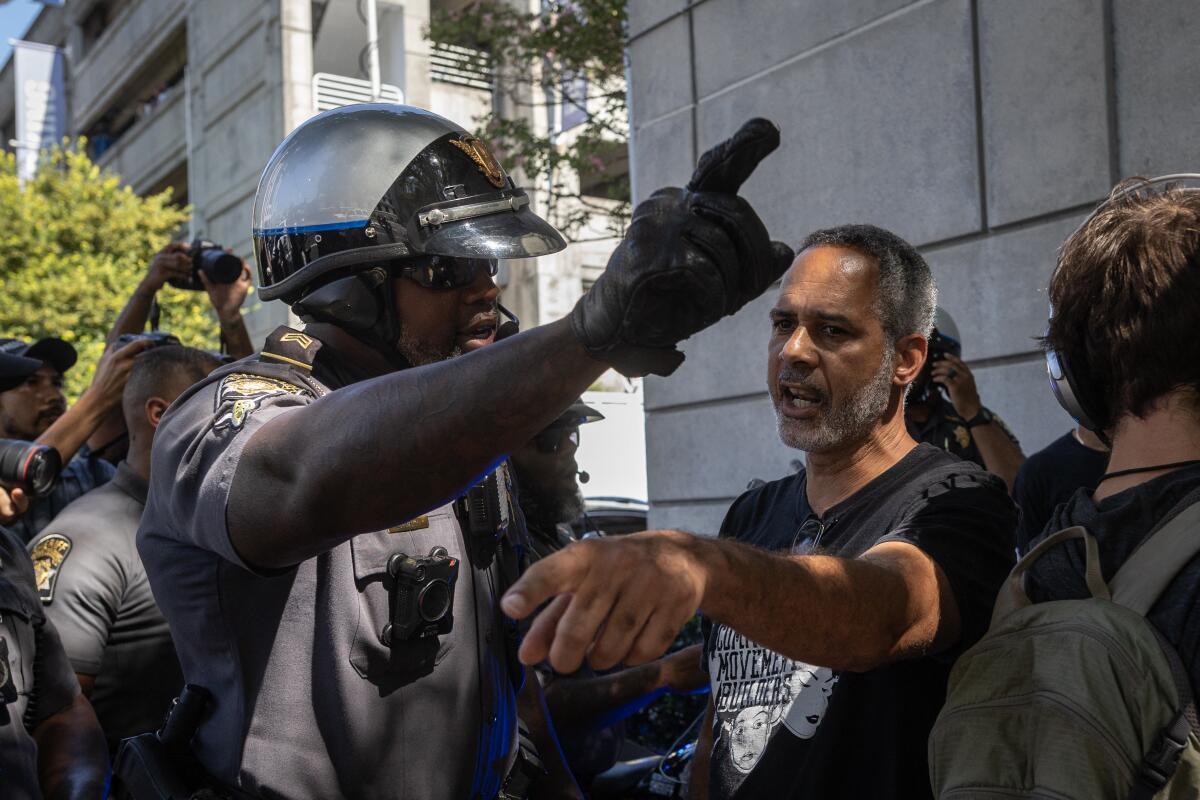 A police officer and a protester argue as protesters