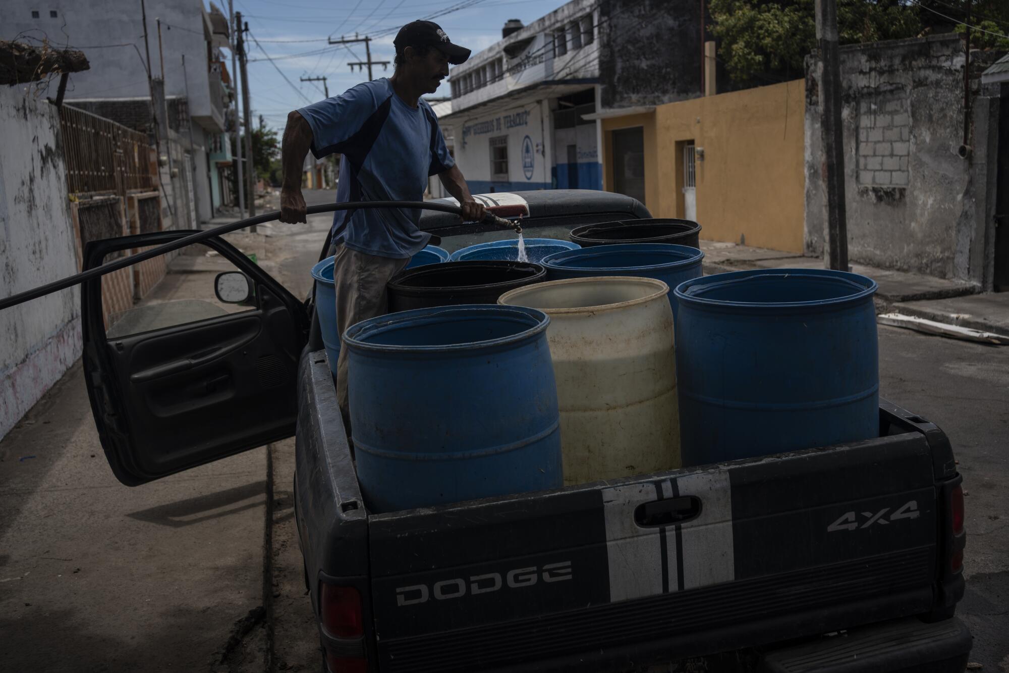 A man fills containers with water due to the shortage caused by high temperatures.