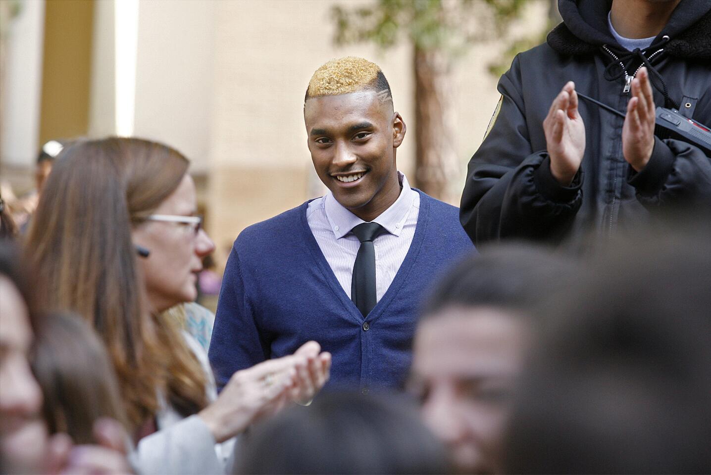 Glendale High School's Michael Davis is all smiles as the crowd in the quad applaud him as he is recognized for his accomplishment of a full-ride scholarship to BYU that his is about to sign in Glendale on Wednesday, February 6, 2013. Davis signed a letter of intent for a full-ride scholarship to Brigham Young University, the first time at Glendale High School since 1992.